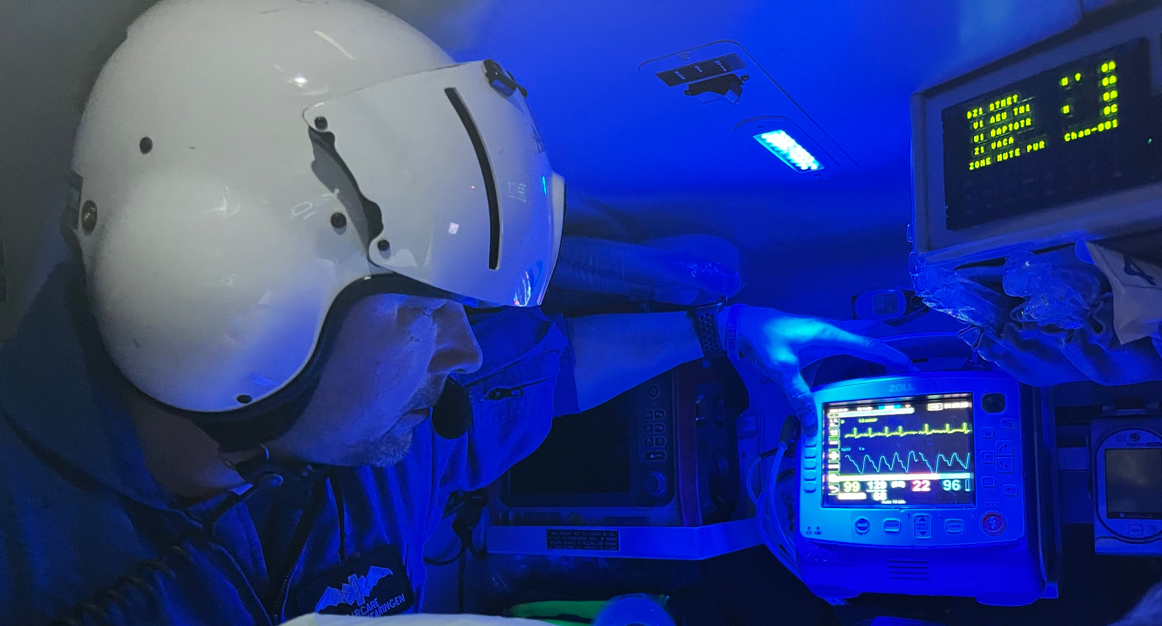 A flight paramedic checks a 12-lead ECG on his patient